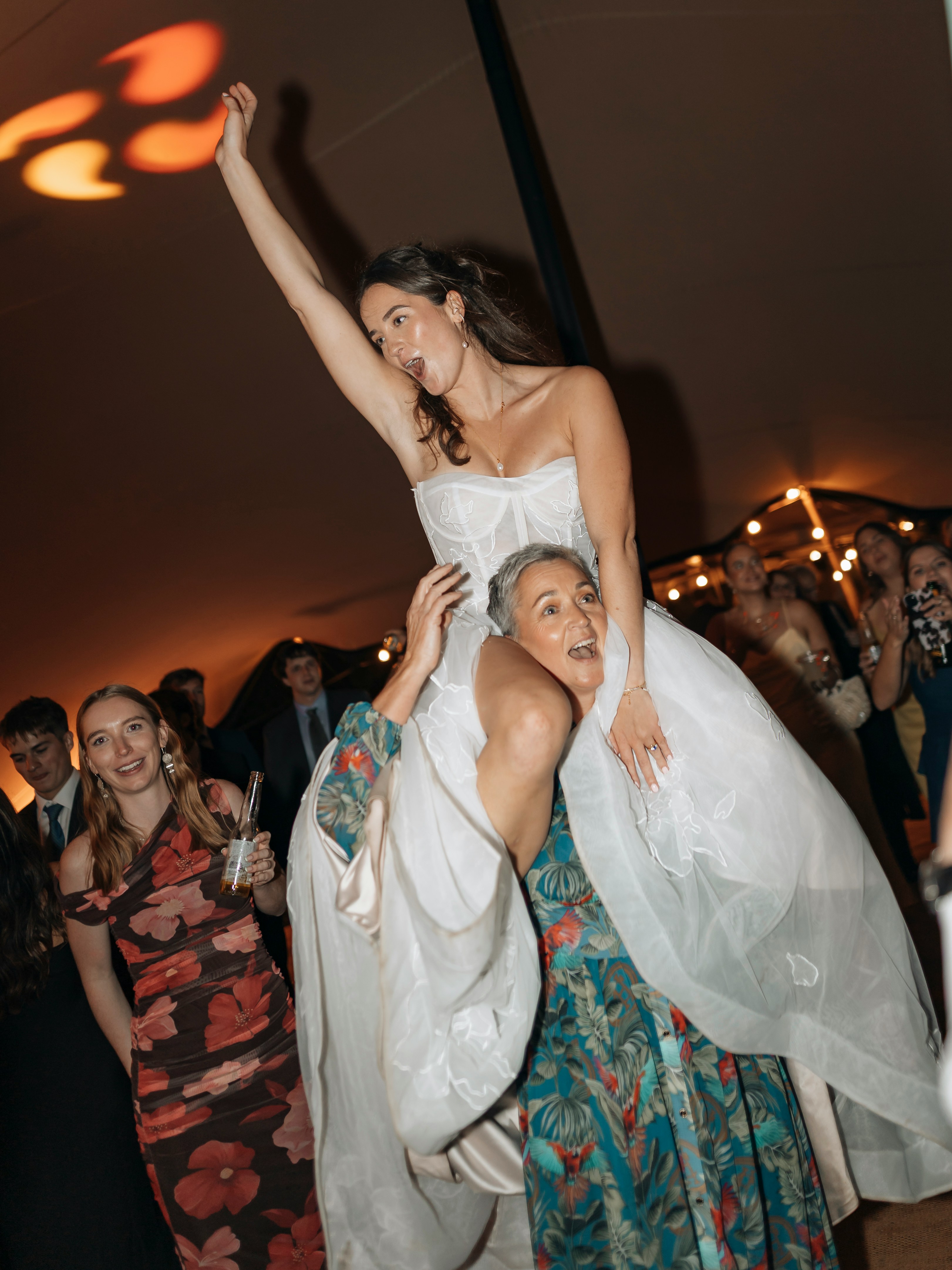 Mariée portée par les invités en soirée